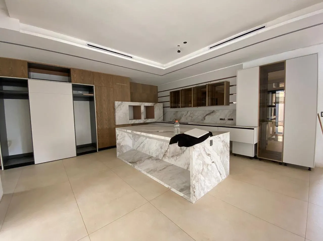 Finished kitchen with marble island and timber-veneer cabinetry