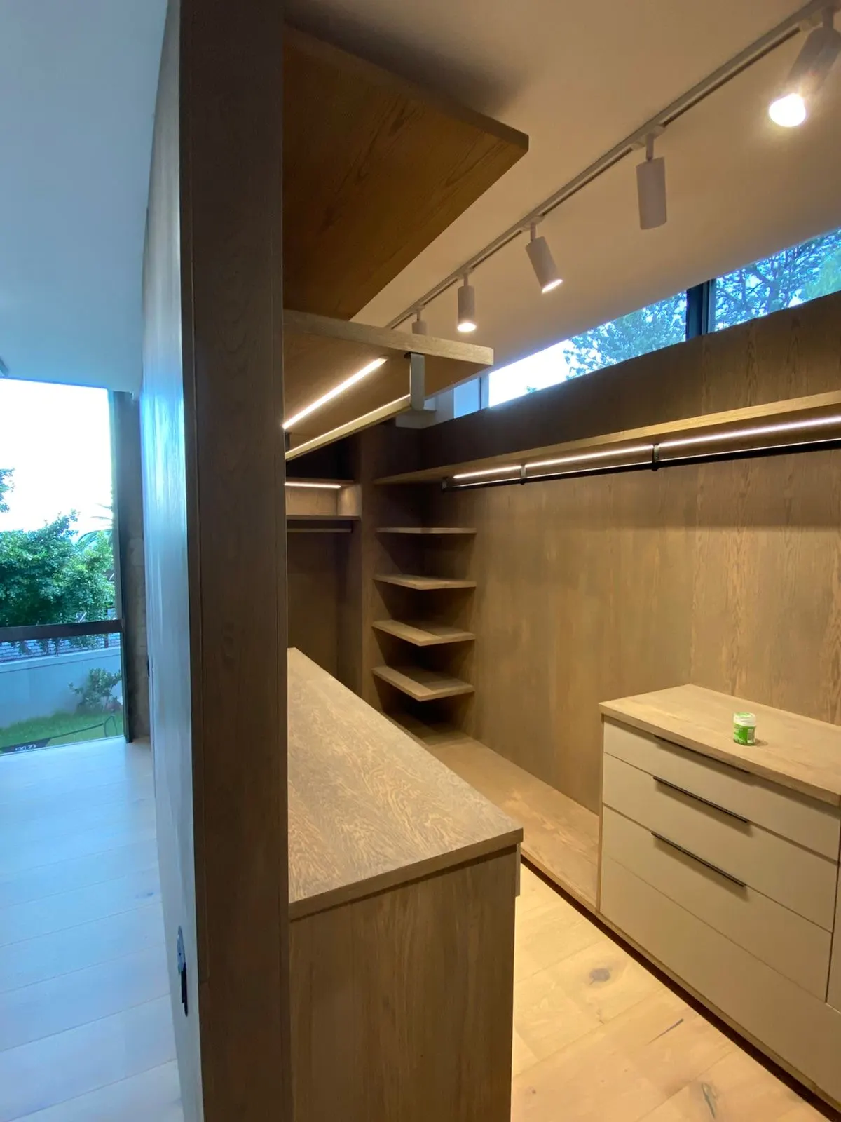 Walk-in closet with oak shelving and LED lighting
