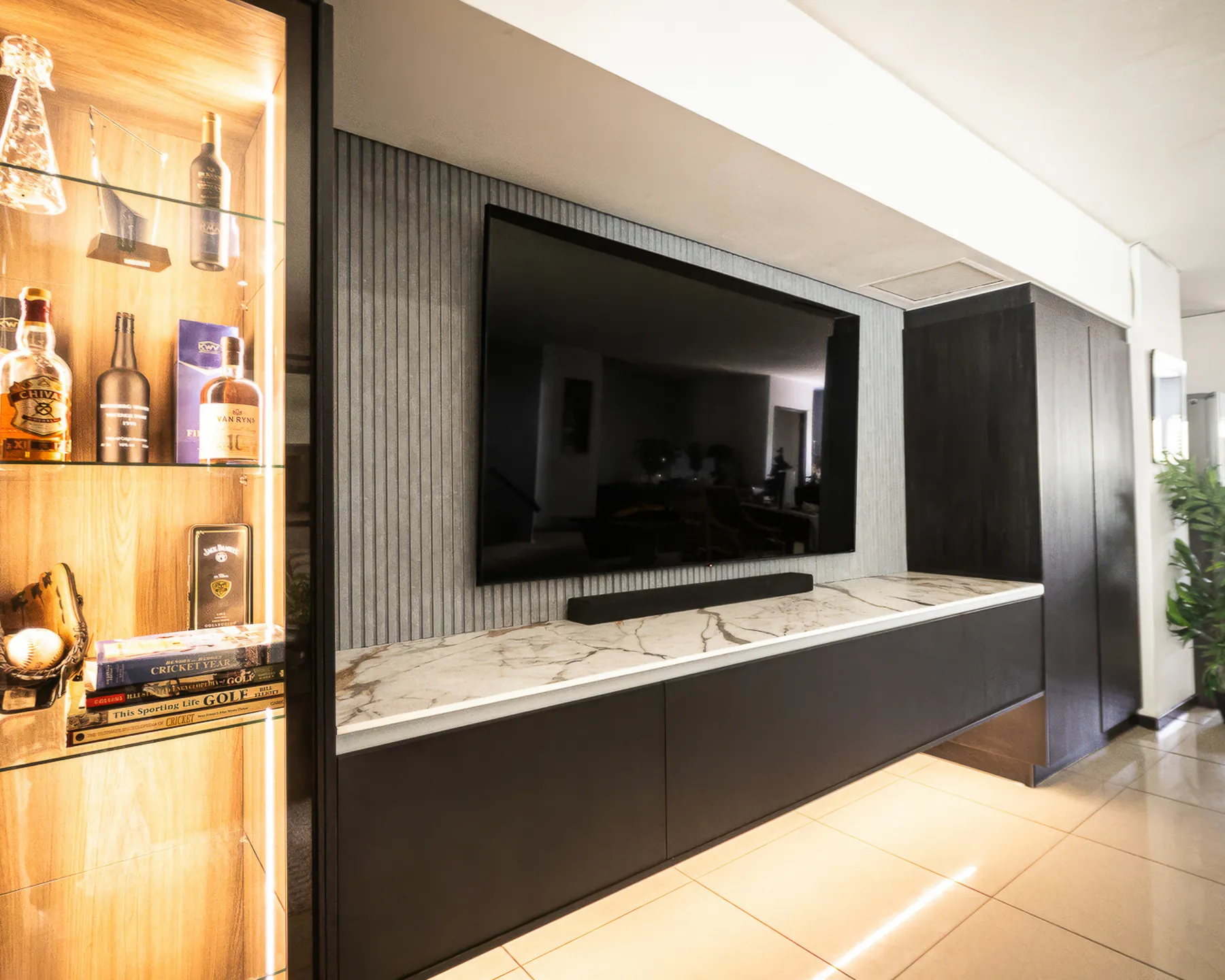 Floating TV wall unit with marble-look top, fluted grey panel and lit display cabinet