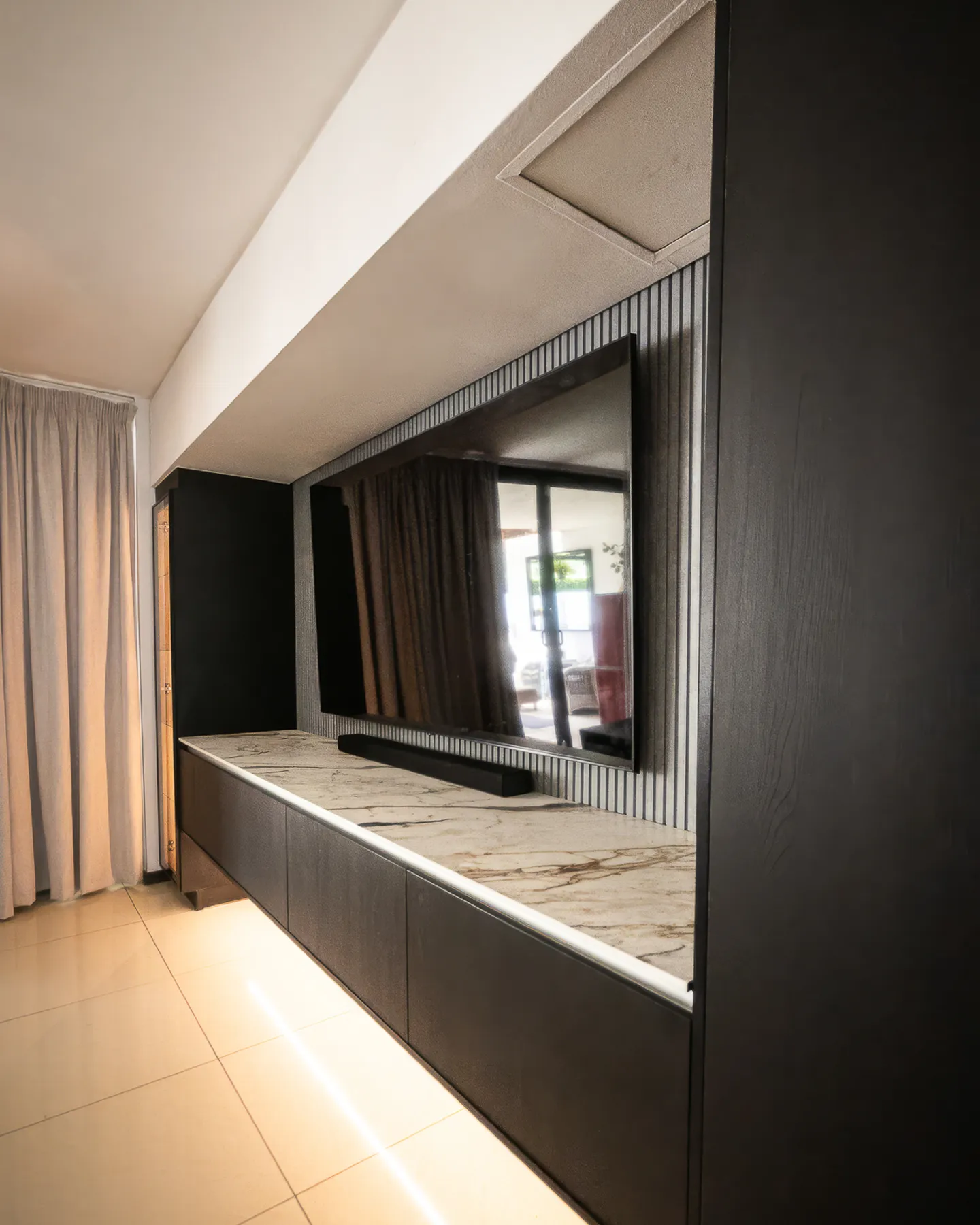 Angled view of the TV unit beside a tall black panel
